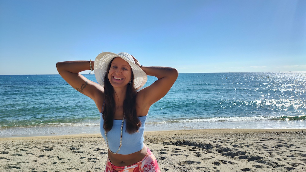 A woman wearing a hat on the beach, seeking startup support.