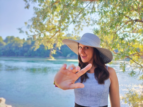 A woman wearing a hat and pointing to the river, providing marketing support.