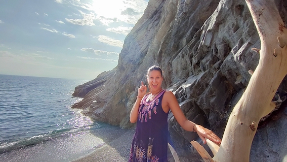 A woman is standing next to a cliff with a cell phone, seeking startup support.