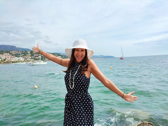 An entrepreneur in a polka dot dress posing by the water.