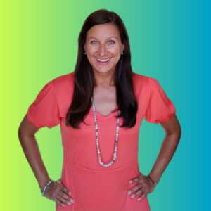 A smiling woman in a pink dress standing in front of a vibrant background, providing marketing support.