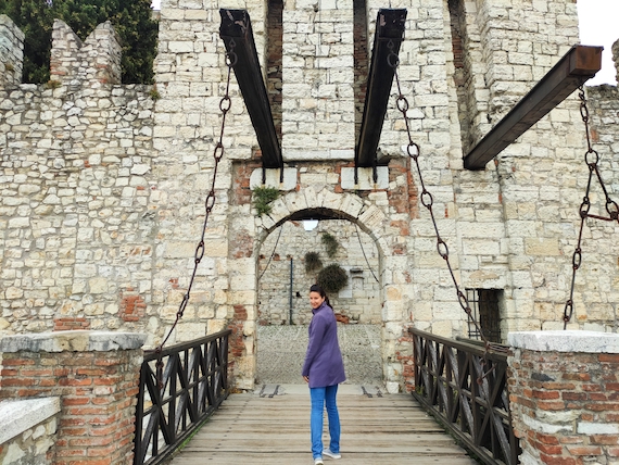 A woman standing on a bridge in front of a marketing support castle.