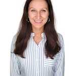 Woman with long hair smiling against a white background.